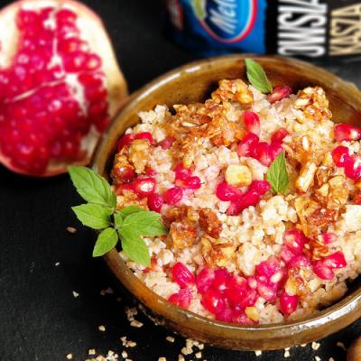 Kremowa kasza owsiana z granatem, słonymi orzechami laskowymi i listkiem mięty